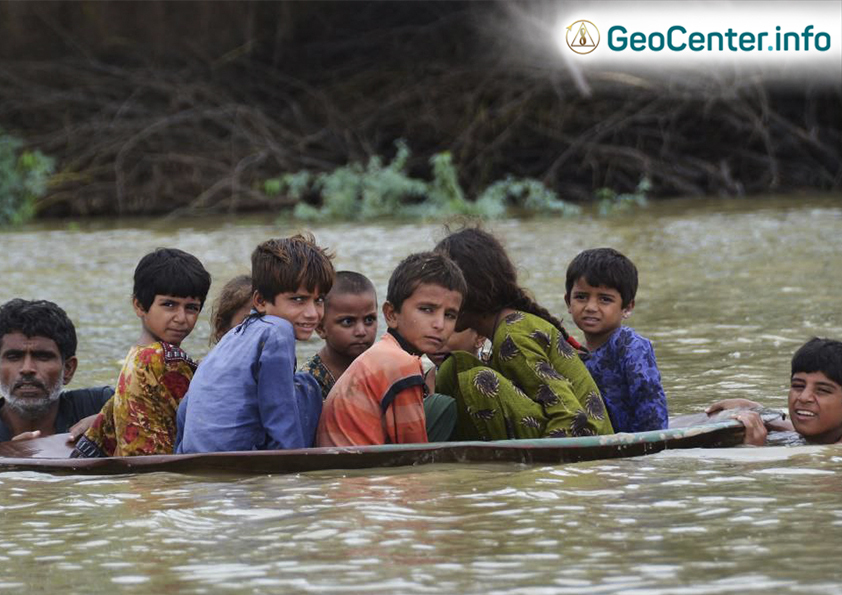 Дети преодолевают затопленную территорию на спутниковой антенне после сильных муссонных дождей в районе Джаффарабад, Пакистан, в 2022 году. Фото: Fida Hussain/AFP/Getty Images