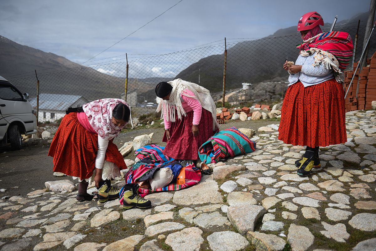 Альпинистки из боливийского коренного народа аймара готовятся к восхождению на заснеженную гору Уайна