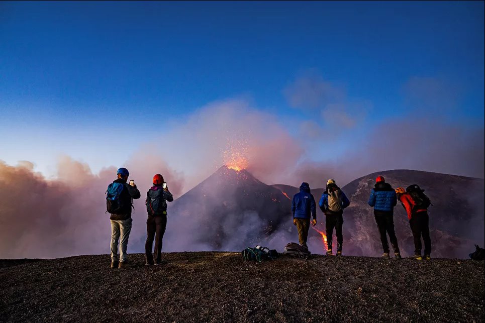 Люди смотрят на лаву, поднимающуюся с кратера вулкана Этна, Италия, 2 июля 2024 года. Фото: Reuters
