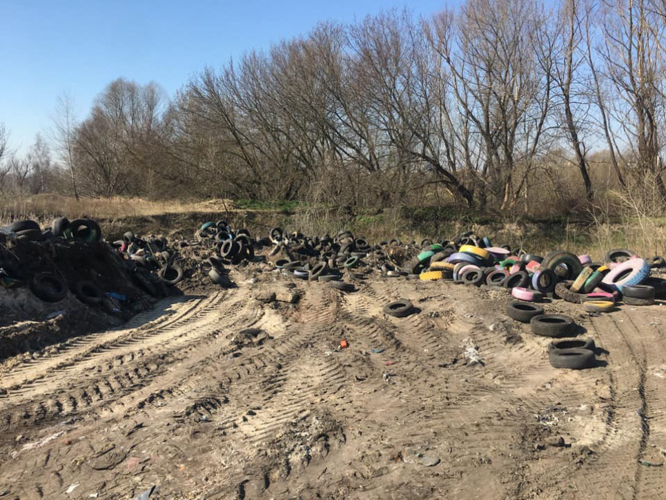 В Киеве зафиксировали «захоронения» покрышек: тонны резины трактор засыпает песком