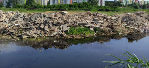 В Буче реку засыпают строительным и бытовым мусором