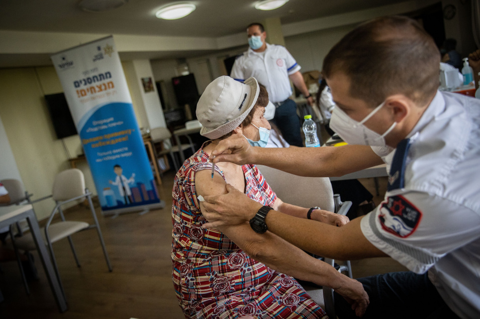 Пожилая израильтянка получает третью дозу вакцины от COVID-19 в пенсионной резиденции в Иерусалиме 4 августа 2021 года (Ионафан Синддел / Flash90)