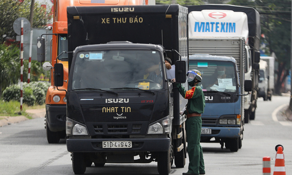 Військовий офіцер перевіряє проїзні документи вантажівки на блокпості Covid-19 у Хошиміні. Фото VnExpress/Quynh Tran