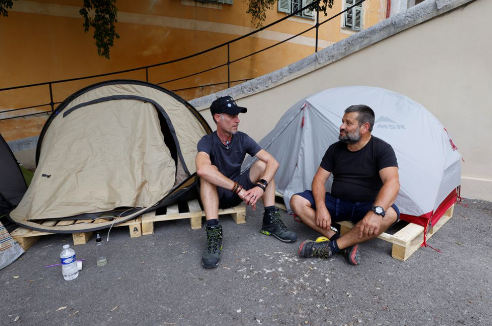 Тьерри Пейзан (справа), работник службы безопасности и пожарный в больнице Пастера, и Кристоф, воспитатель в больнице Пастера, сидят перед своими палатками во время голодовки в знак протеста против вакцинных ограничений во Франции. Фото: Reuters 