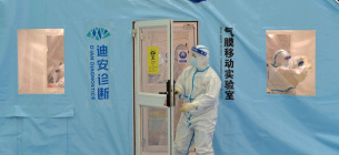 Співробітник відчиняє двері у тимчасовий центр тестування на COVID-19 у Тяньцзіні. STR/AFP VIA GETTY IMAGES