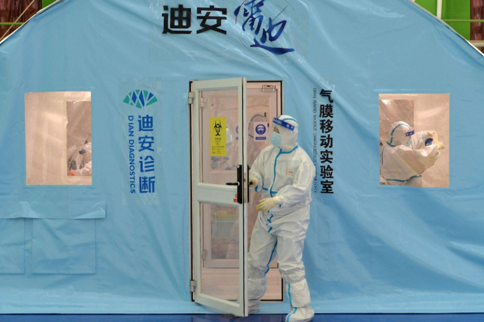 Співробітник відчиняє двері у тимчасовий центр тестування на COVID-19 у Тяньцзіні. STR/AFP VIA GETTY IMAGES