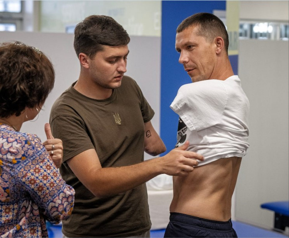 Мінветеранів розширює медичні та соціальні можливості Михальчуку допомагає одягнути сорочку його товариш поранений український ветеран Денис Стратійшук. Фото: Білл О'Лірі/The Washington Post