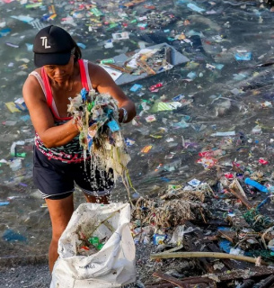 Волонтер збирає сміття вздовж узбережжя Манільської затоки під час акції з нагоди Міжнародного дня прибирання узбережжя. Фото: Руель Умалі/dpa