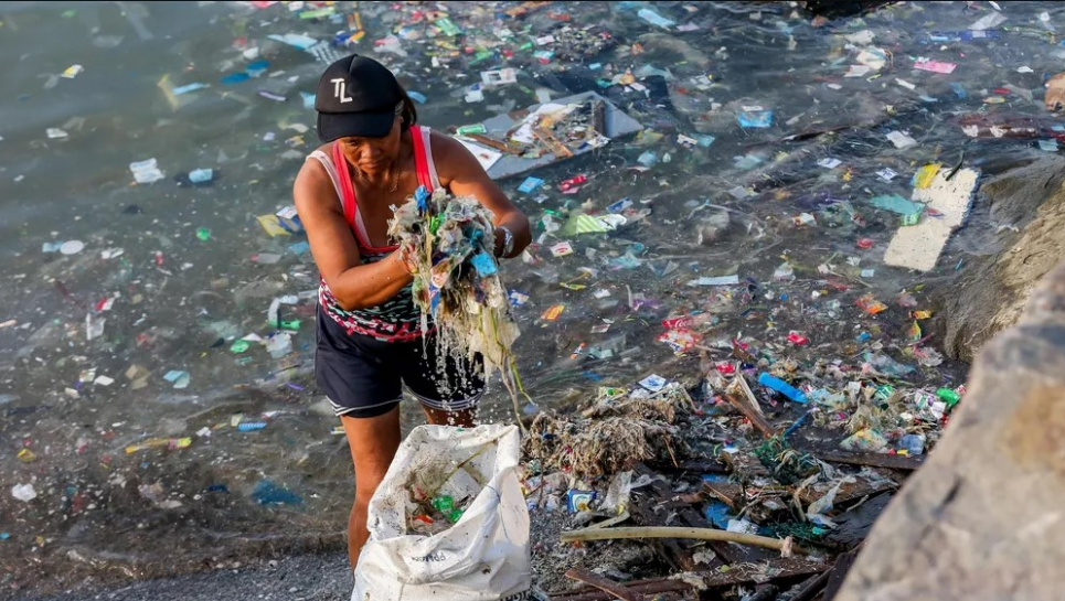 Волонтер збирає сміття вздовж узбережжя Манільської затоки під час акції з нагоди Міжнародного дня прибирання узбережжя. Фото: Руель Умалі/dpa