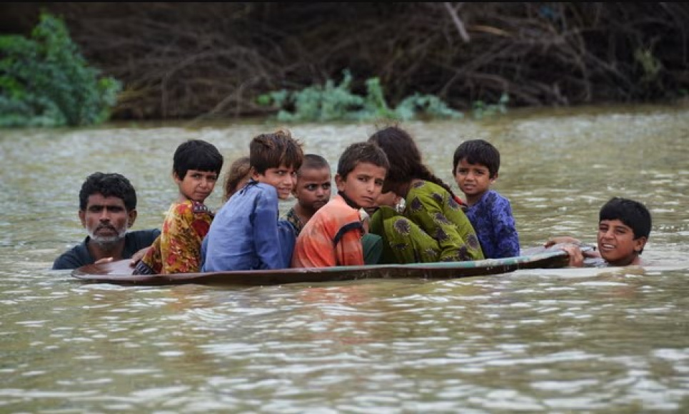 Діти долають затоплену територію на супутниковій антені після сильних мусонних дощів у районі Джаффарабад, Пакистан, у 2022 році. Фото: Fida Hussain/AFP/Getty Images