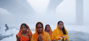 Індуїстські вірниці поклоняються богу Сонця, стоячи на березі забрудненої річки Ямуна під час індуїстського релігійного свята Чхатх Пуджа в Нью-Делі, Індія, 19 листопада 2023 року. Фото: Reuters