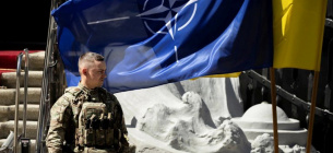 Український бойовий досвід виявив слабкі місця НАТО Солдат під прапорами НАТО та України. Фото: Thomas Peter / Reuters