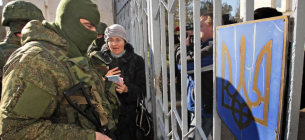 "Зелені чоловічки" блокують українських військових у в\ч в Новоозерному, що неподалік Євпаторії. 3 березня 2014 року. Фото: EPA