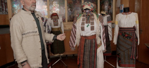 Николай Шкрибляк демонстрирует вышитую рубашку 1923 года из села Подзахаричи на Буковине из своей коллекции. Фото: Суспільне Черновці