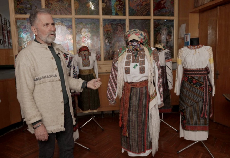 Микола Шкрібляк показує вишиту сорочку 1923 року із села Підзахаричі на Буковині зі своєї колекції. Фото: Суспільне Чернівці
